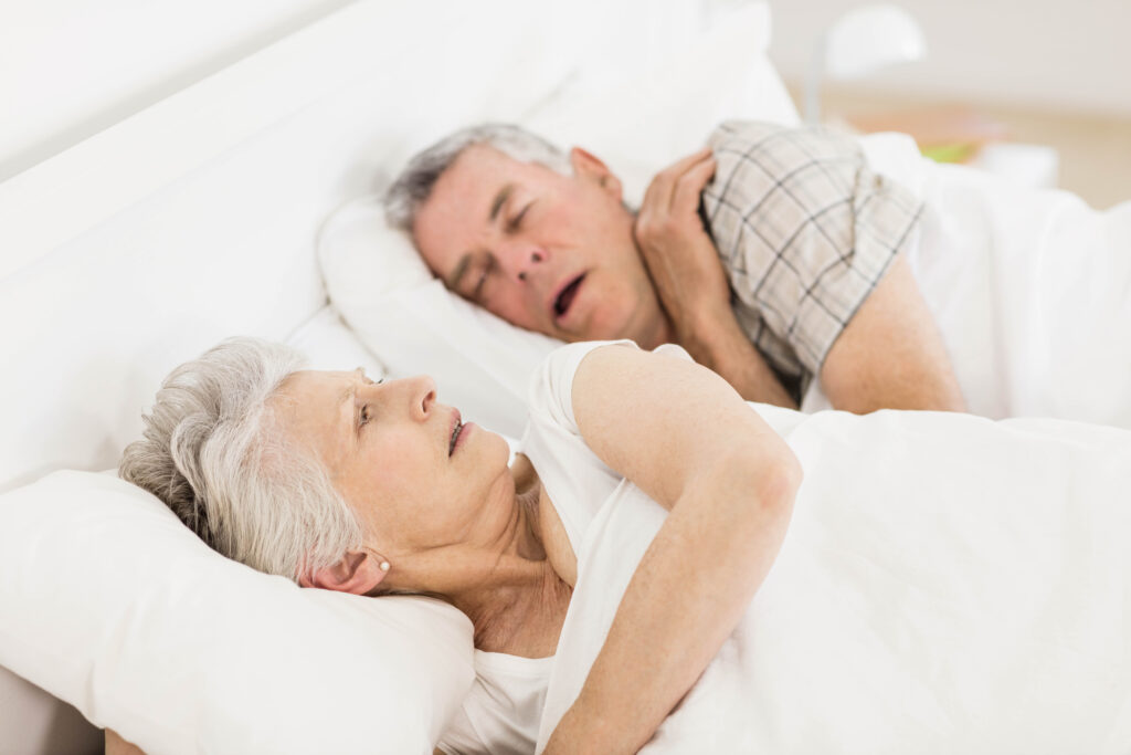 Woman awake while husband snores