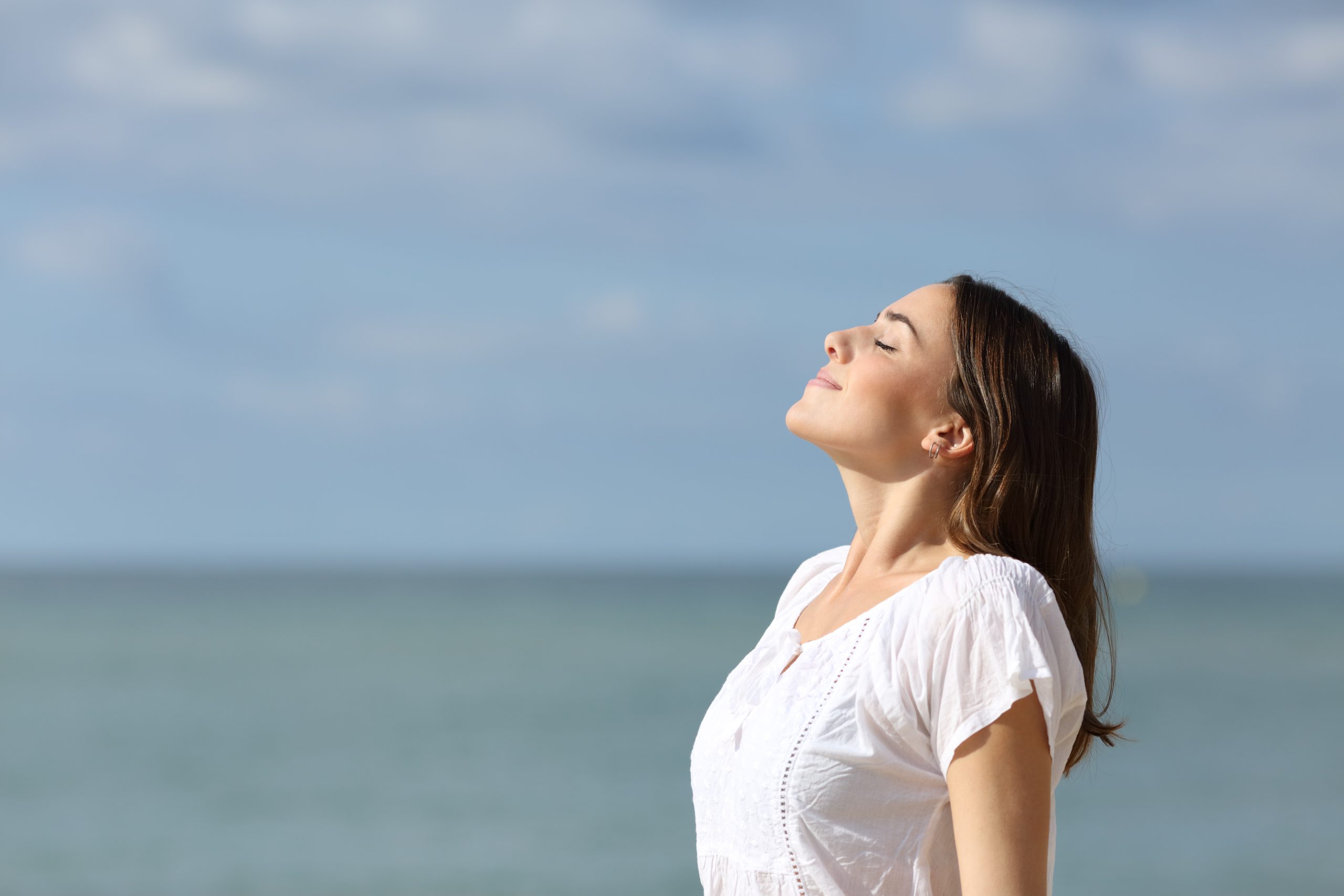 woman standing near the smiles up at the sun