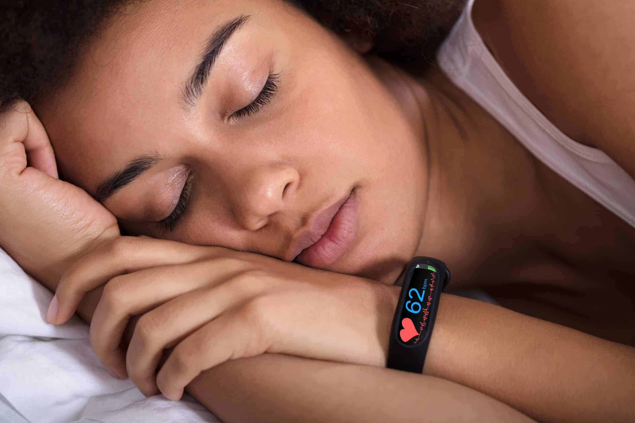 woman sleeping with smart device tracking metrics