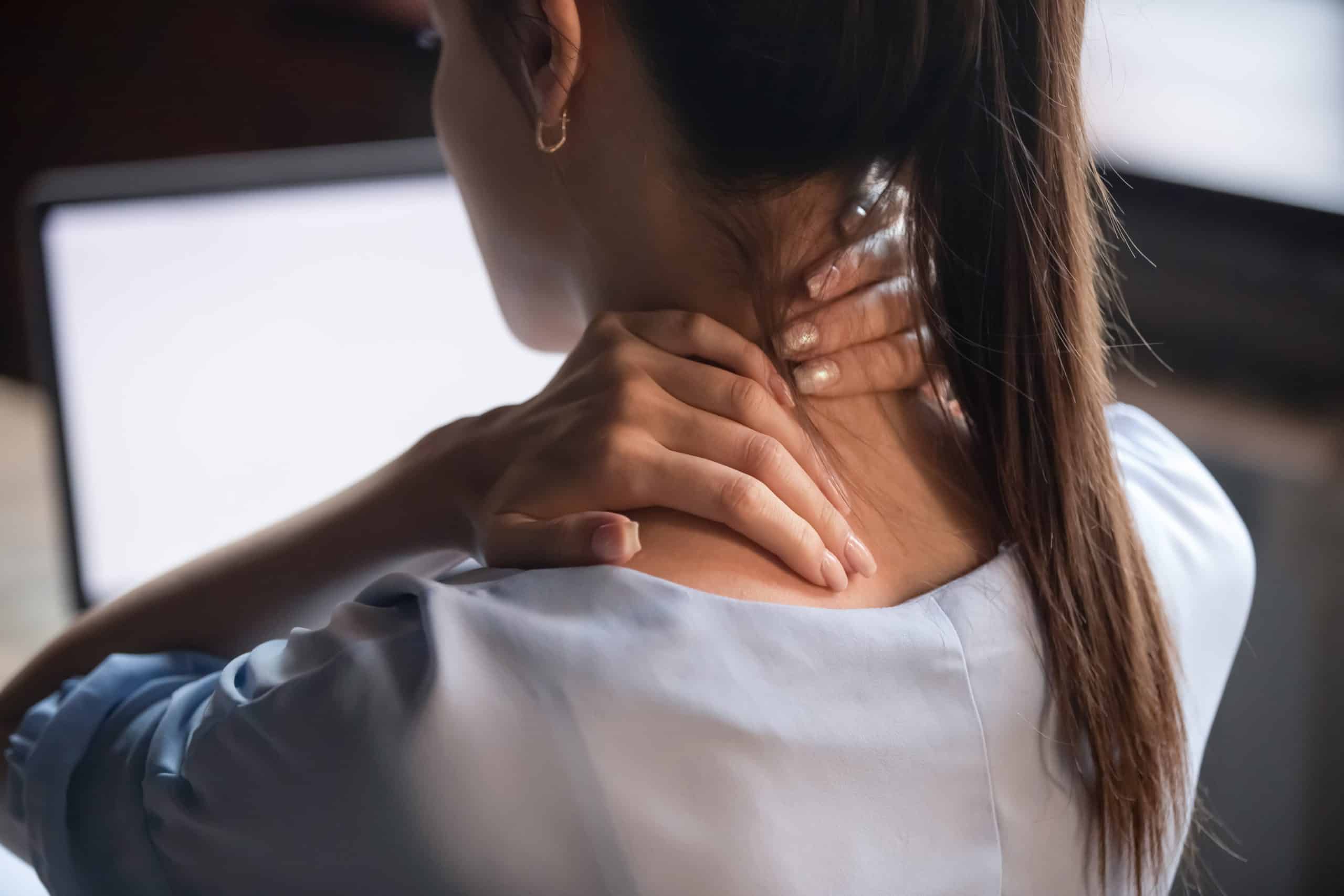 woman clasps either side of neck in pain