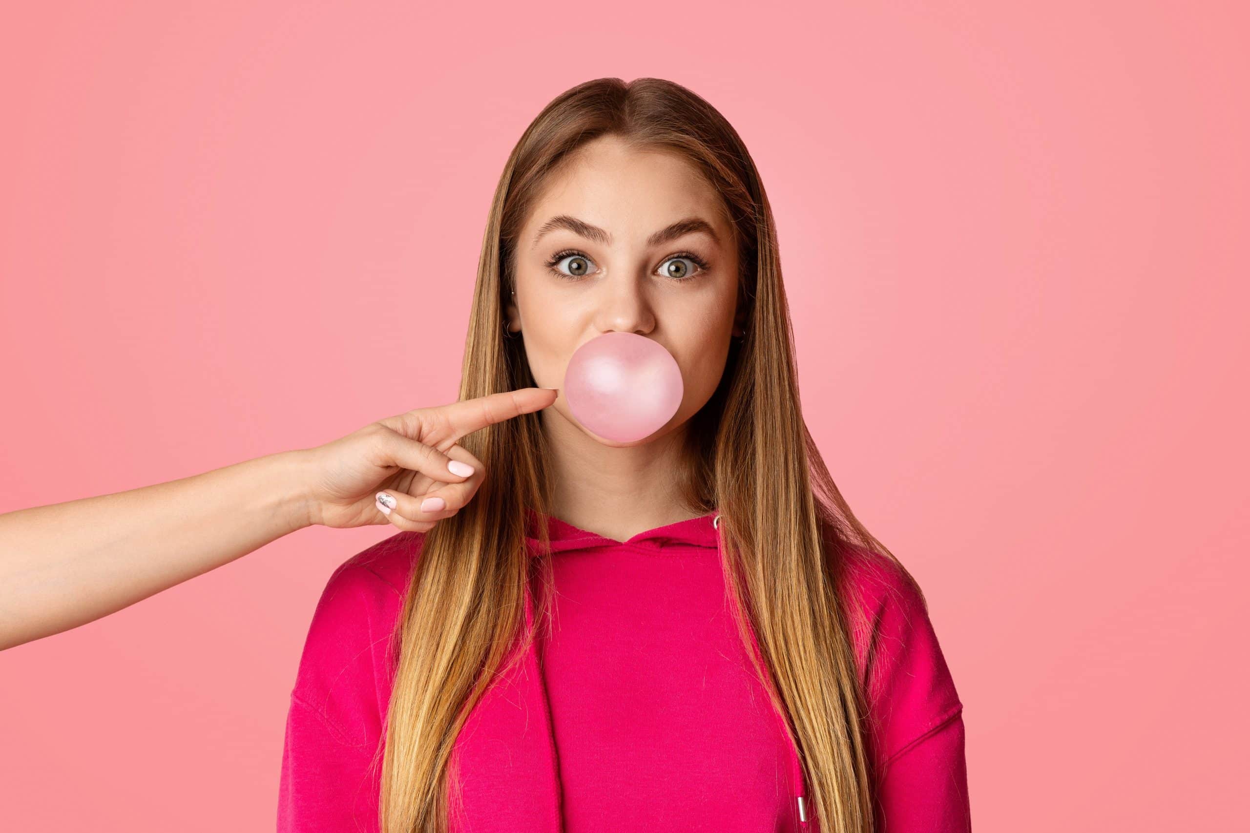 teenager chewing gum blowing a bubble