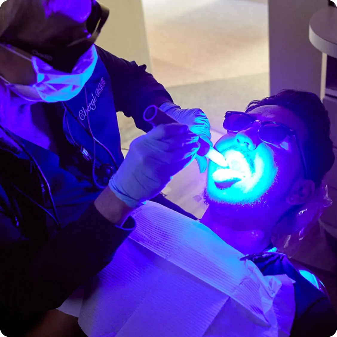 Clinician using an oral screening light during a dental examination