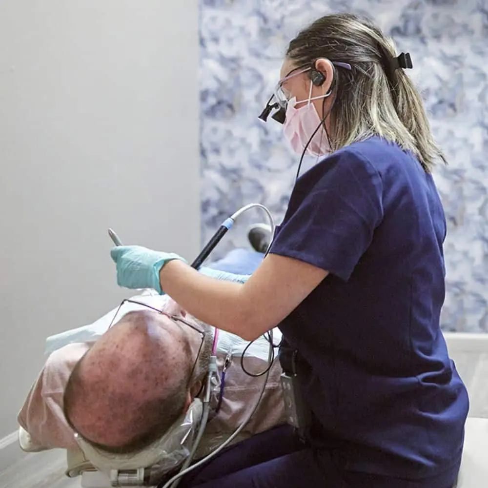 Dentist carefully examining a patient's teeth and gums