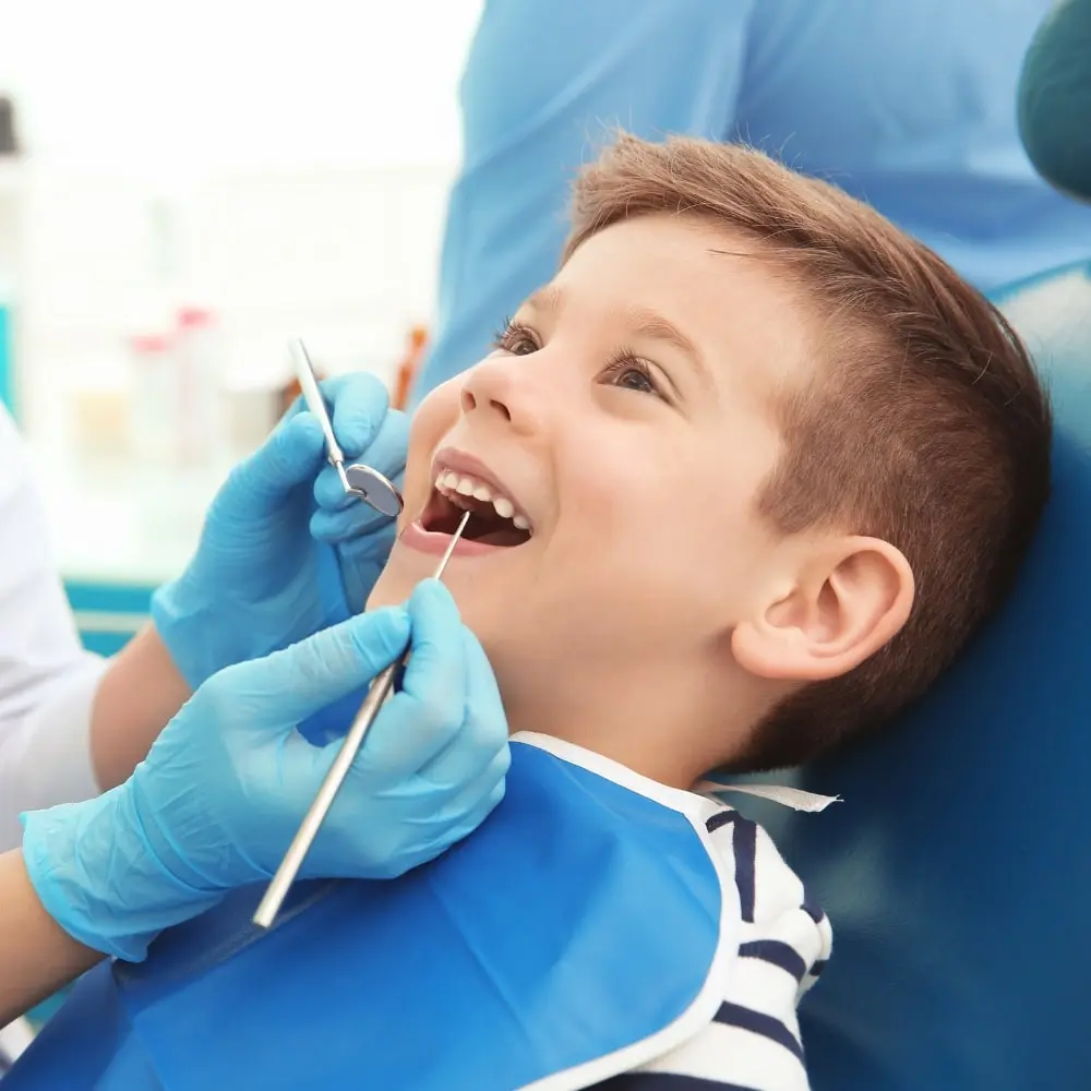Quick fluoride treatment being applied to a child’s teeth