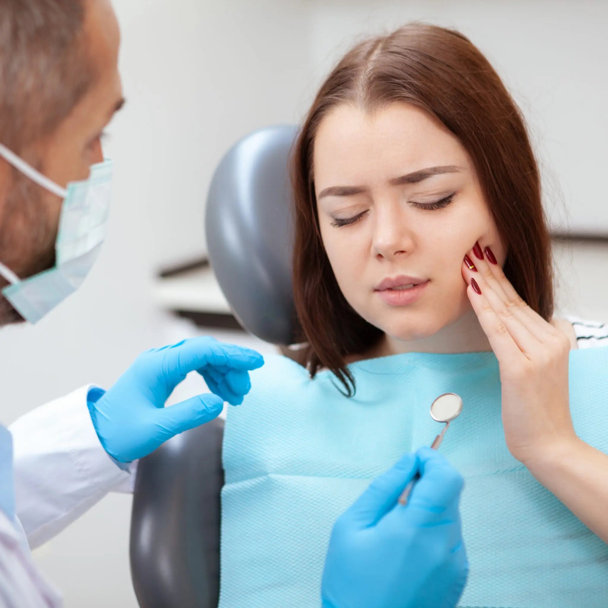Dentist assessing a patient who needs urgent dental care