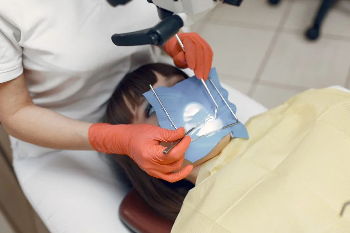 Dentist performing a precise cosmetic dental procedure in a modern clinic