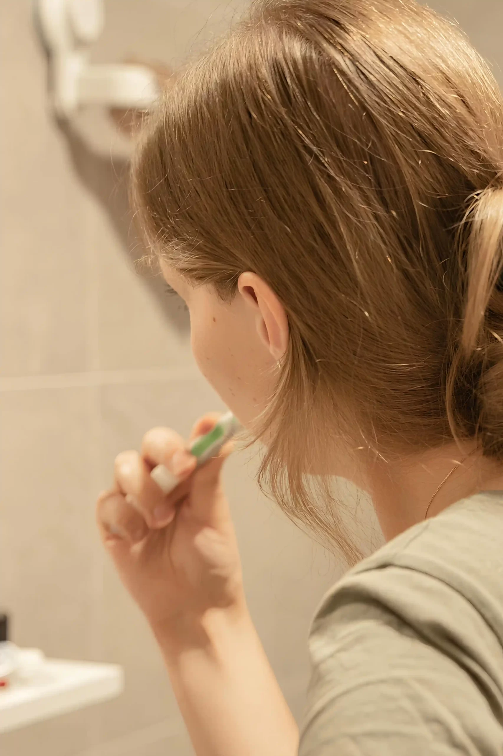 Woman brushing her teeth as part of daily care for her smile