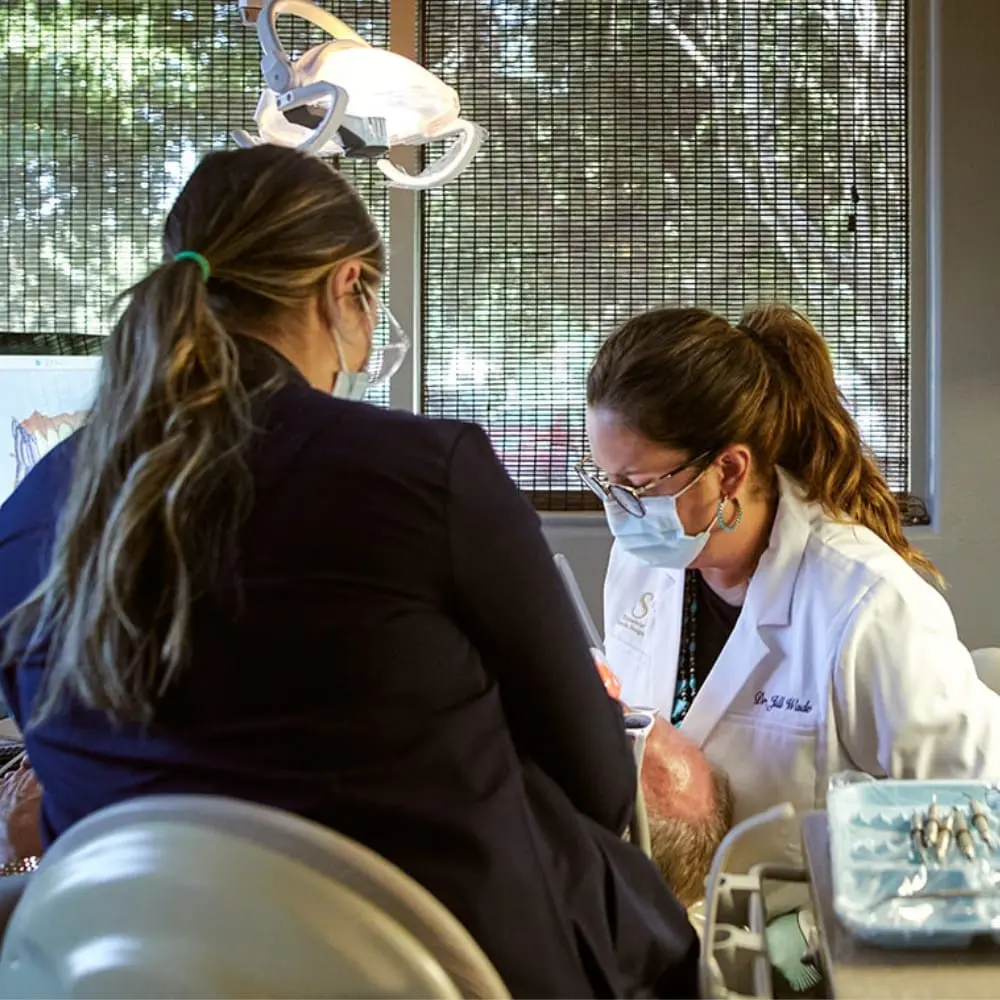 Clinician monitoring a patient receiving intravenous dental sedation